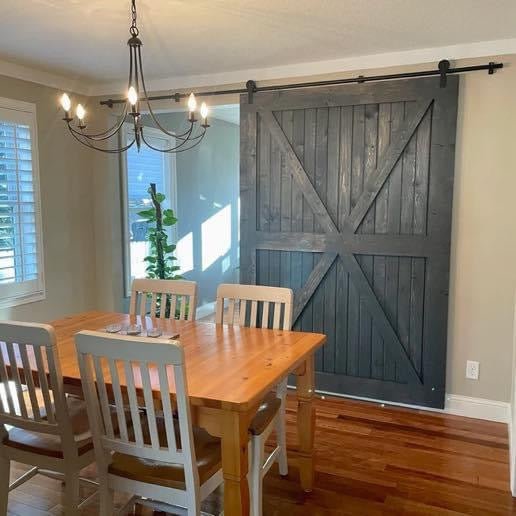 Custom doors for stylish spaces in a modern dining area featuring a barn door and wooden dining table.