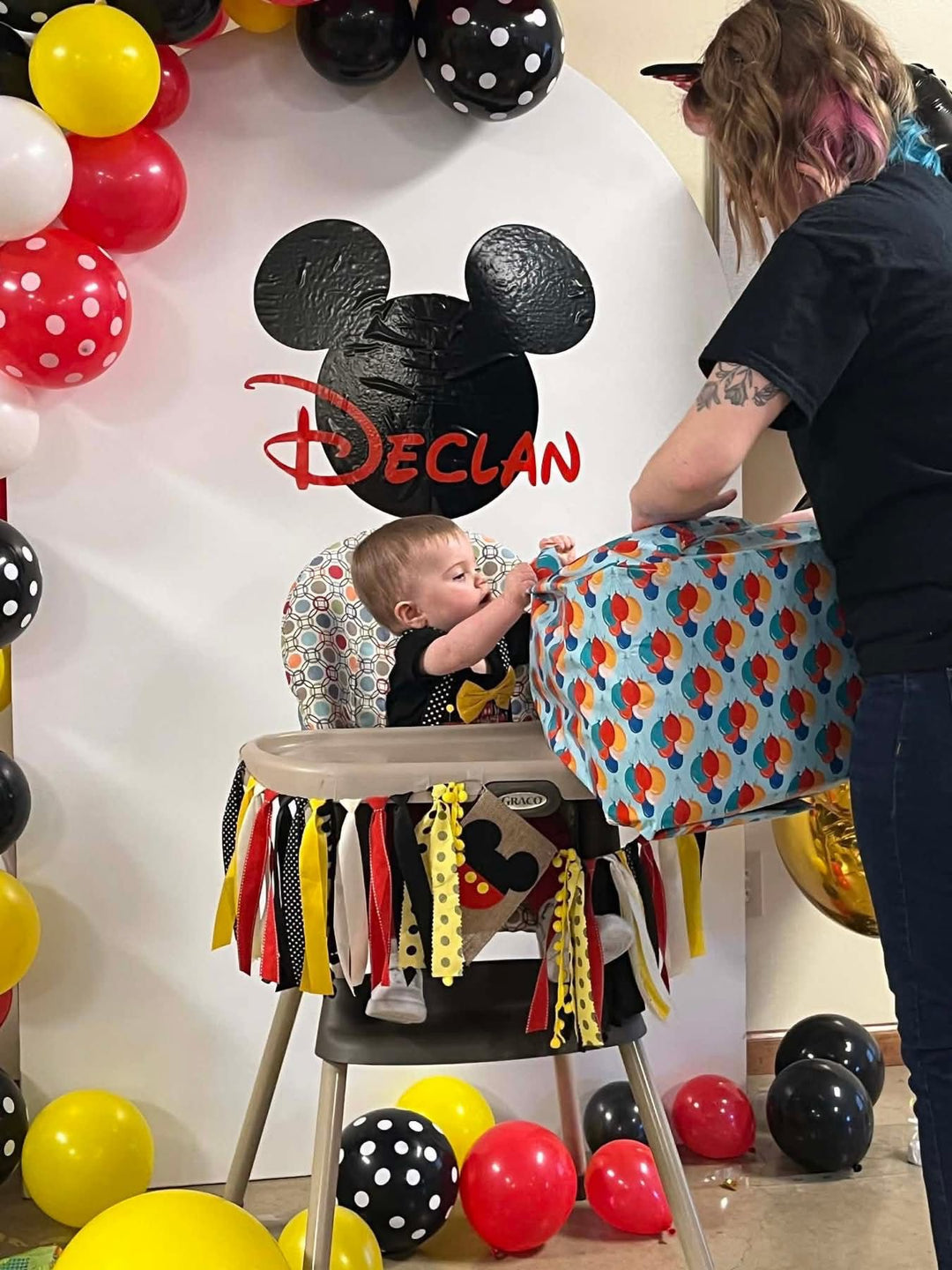 6th custom event backdrop panel a gift at a Mickey Mouse-themed birthday party with colorful balloons and a custom backdrop featuring the name Declan.