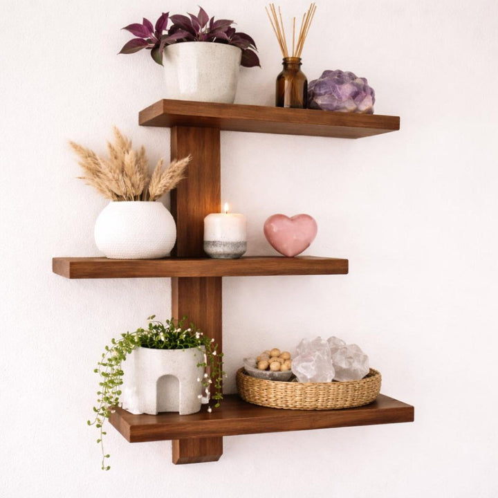 Floating wood trinket shelves showcasing plants, candles, and decorative items for organized storage.
