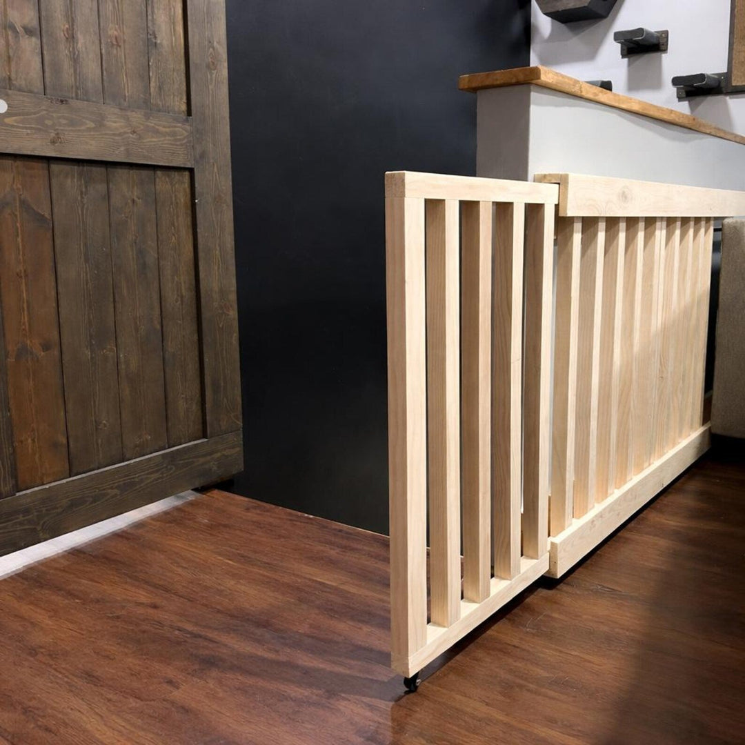 Retractable wall mounted baby gate installed near a wooden door, demonstrating safe containment for children.