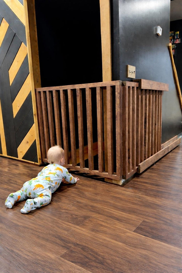 Infant crawling towards a retractable wall mounted baby gate, showcasing safety and space-saving design.